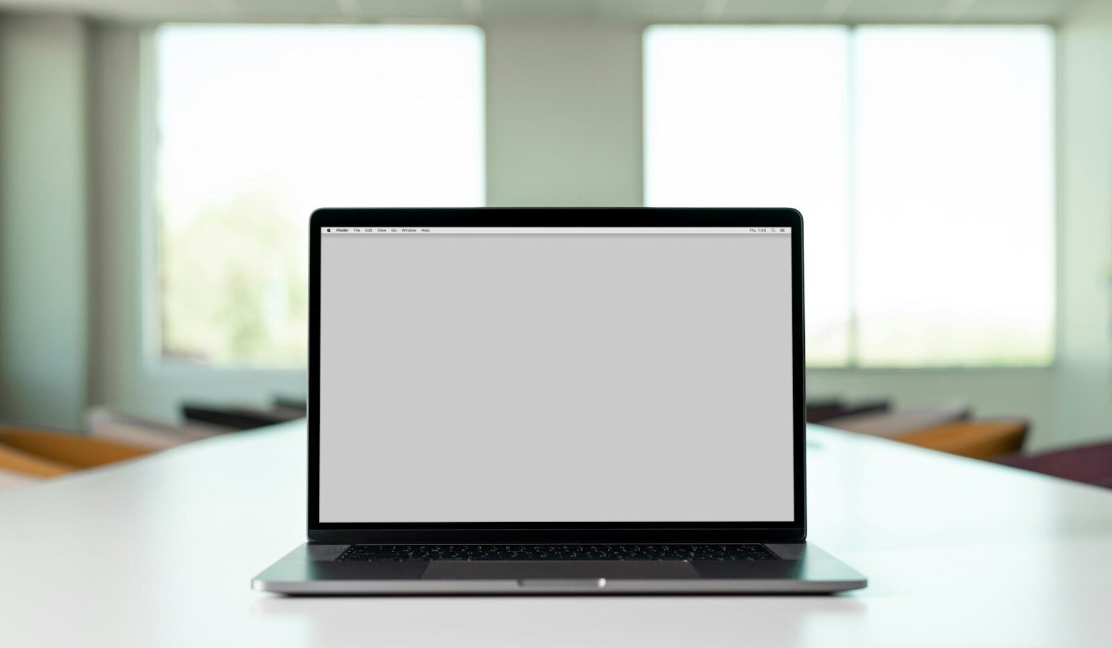 An open laptop computer sitting on a bright white desk