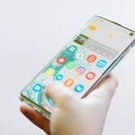 Person holding an Android smartphone full of colorful app icons, illustrating tips for freeing up phone storage