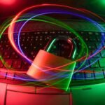 Padlock on a laptop keyboard surrounded by glowing light trails, illustrating passwords and two-factor authentication for securing online accounts